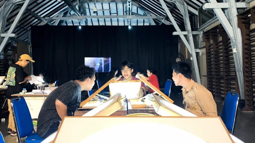 Peserta mewarnai frame rotoscoping di meja workshop Tracing The Heritage oleh Rimbun Project, Kotabaru Heritage Film Festival 2025.