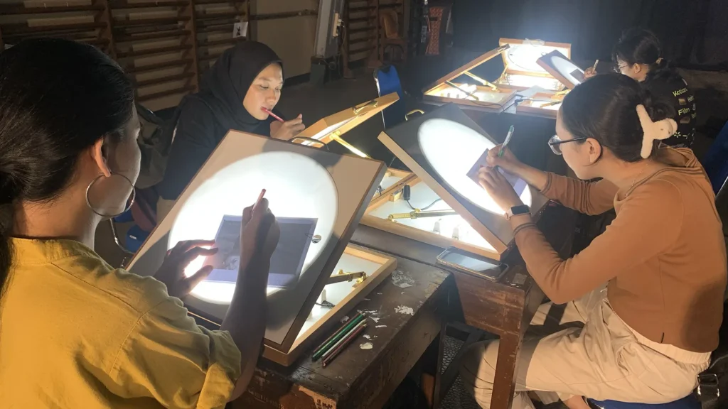 Peserta mewarnai frame rotoscoping di meja workshop Tracing The Heritage oleh Rimbun Project, Kotabaru Heritage Film Festival 2025.
